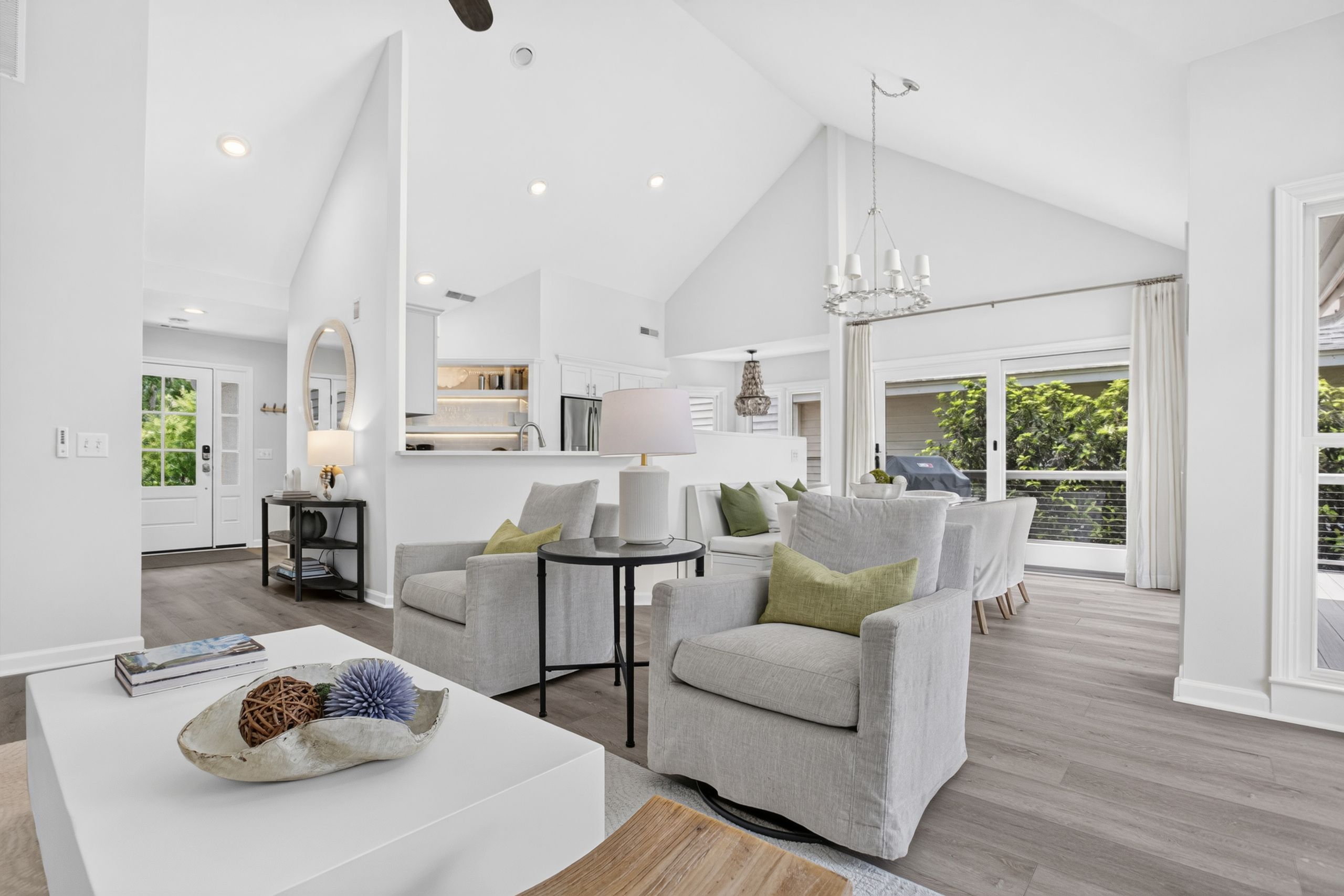 A spacious living area with a high ceiling, a dining area with a view, and a kitchen with modern appliances.