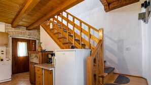 A kitchen with a wooden staircase leading to a loft area. - Walnut House with a pool (Nedešćina)