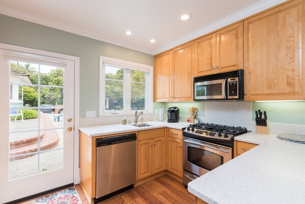 A kitchen with wooden cabinets, a dishwasher, a stove, and a microwave.