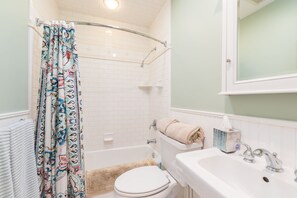Ein Badezimmer mit Toilette, Badewanne, Waschbecken und einer Duschvorhang.