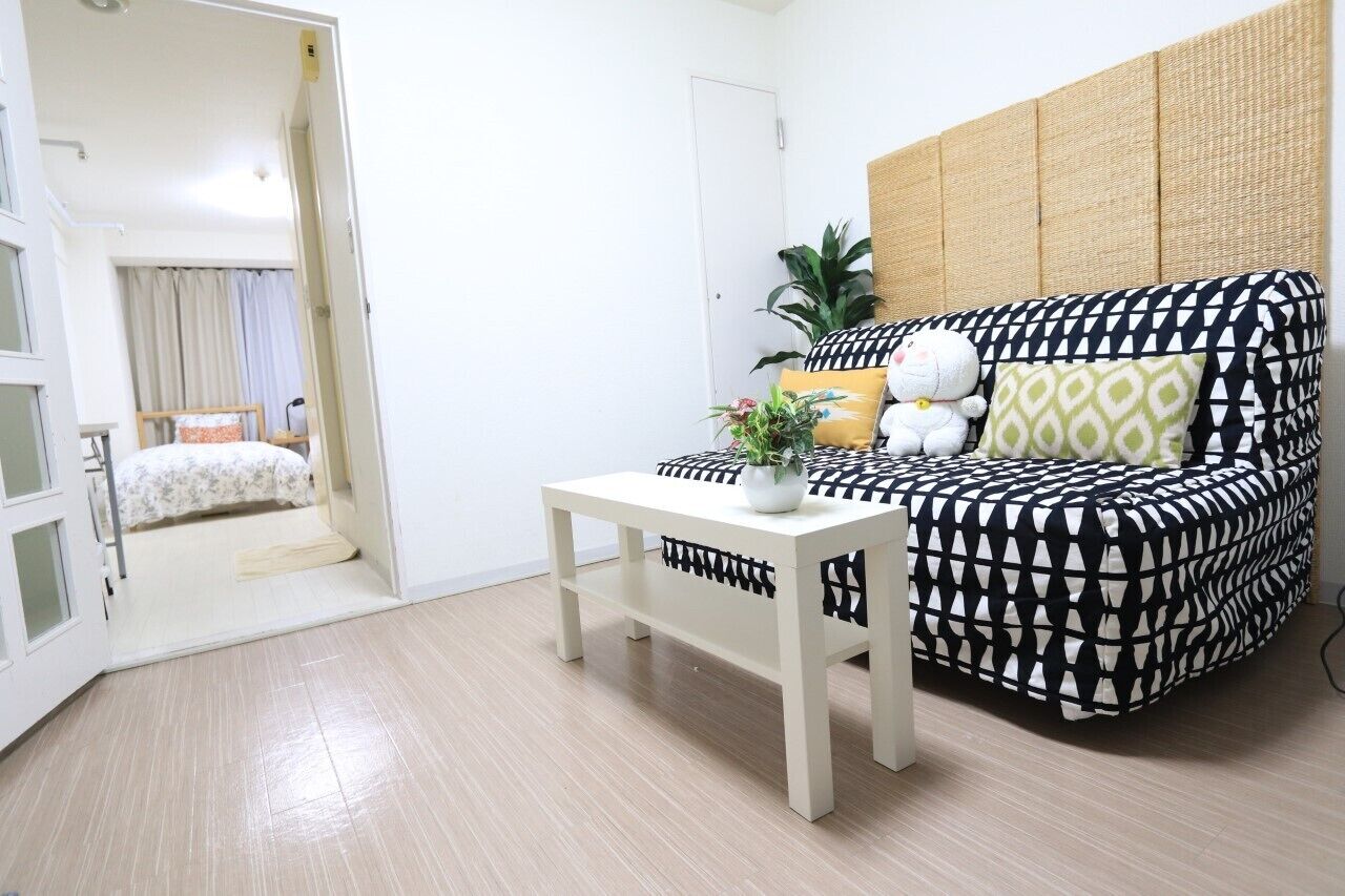 A compact living space with a sofa, a small table, and a bed.