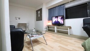 A living room with a glass coffee table, a television, and a sofa. - Residence Osaka Nipponbashi (Osaka)