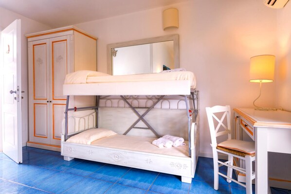 A bunk bed with a desk and chair, a wardrobe, and a mirror. - Janas Hotel (Villasimius)