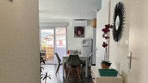 A modern kitchen with a dining area, a refrigerator, and a decorative mirror.