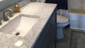 A bathroom with a white sink, a mirror, a toilet, and a shower curtain. - Ledges Complex - Lake front With Slip Included - Beach and 2 Pools (Osage Beach)