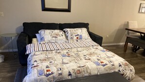A neatly arranged bedroom with a bed, a small table, and a bench. - Ledges Complex - Lake front With Slip Included - Beach and 2 Pools (Osage Beach)