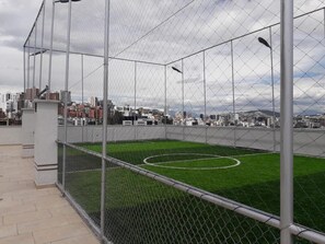A fenced sports court with a cityscape in the background. - EXCLUSIVE DEPARTMENT (Quito)