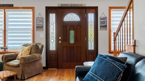 A wooden door with a welcome sign, a bench, a chair, and a staircase. - York Beach Getaway (Razzle Dazzle House) (York)