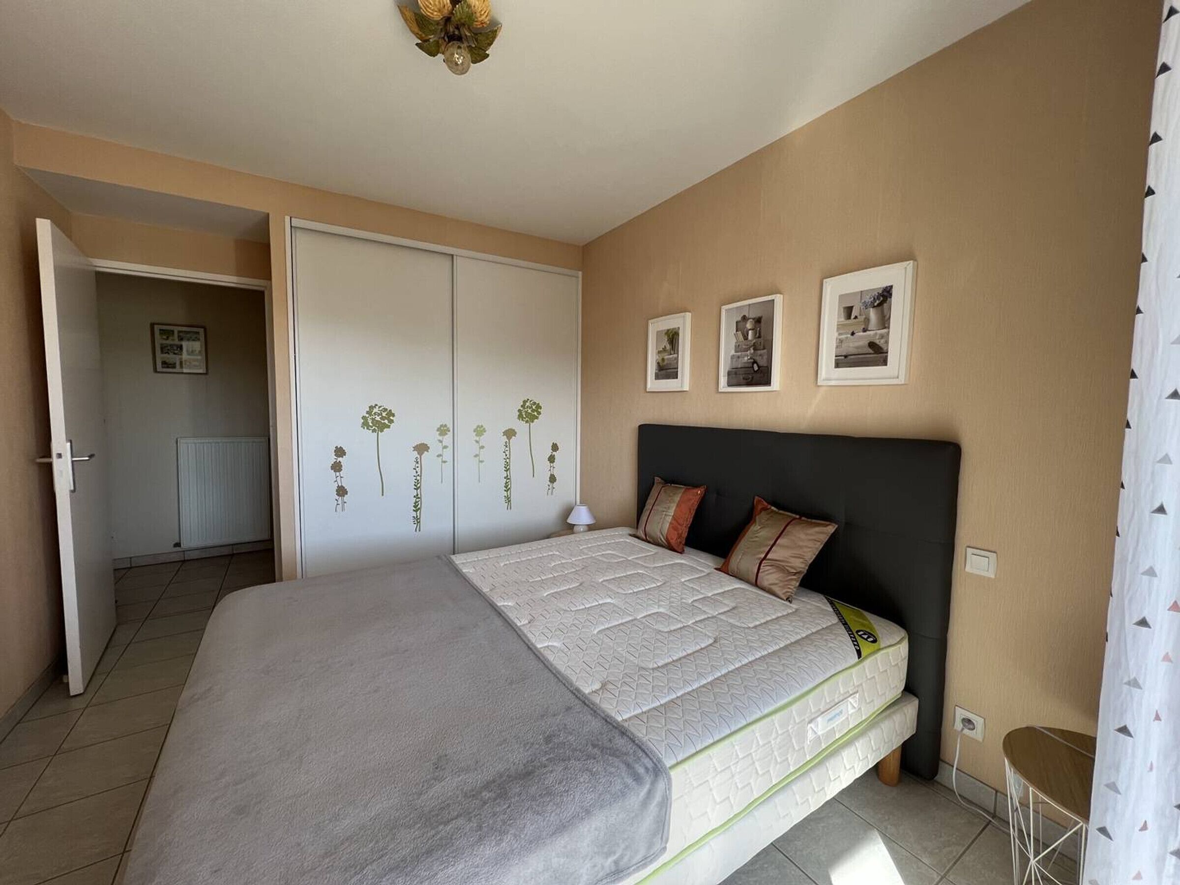 Un dormitorio con cama, armario y ventilador de techo.
