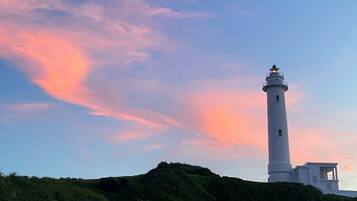Un faro en una colina bajo un cielo despejado.