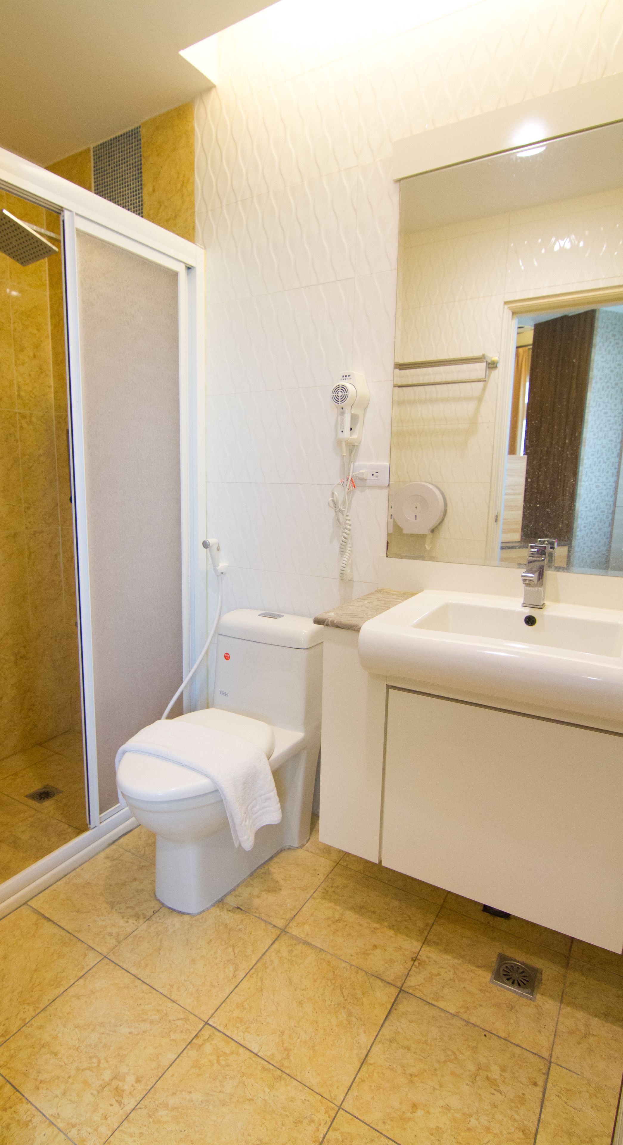 A bathroom with a toilet, a sink, and a shower area.