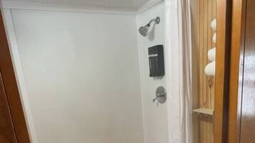 Een kleine badkamer met douche, toilet en wastafel.
