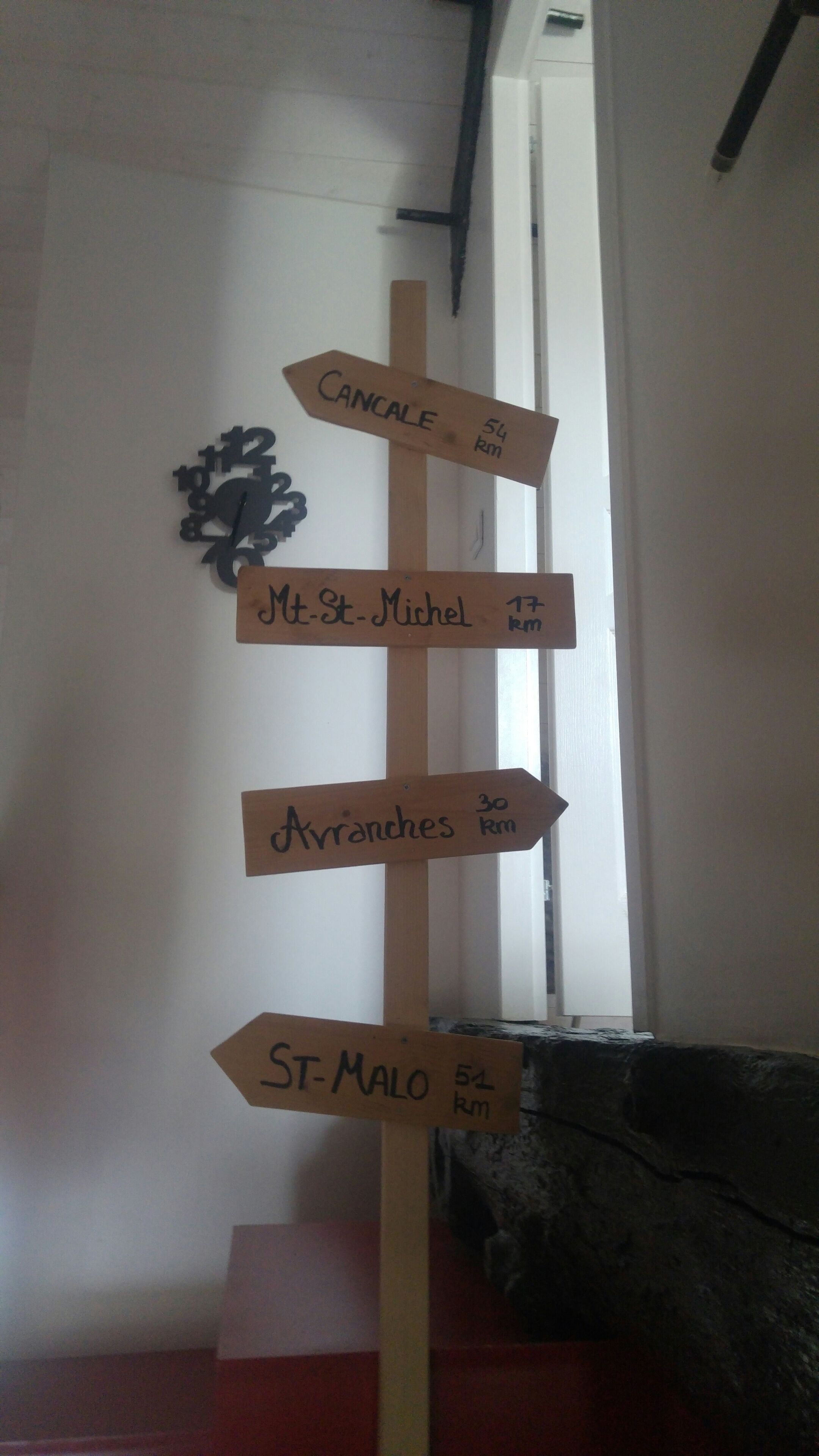 A wooden signpost with directional signs pointing to various destinations and distances.