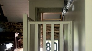 Ein mehrgeschossiges Zimmer mit Etagenbett, Treppe und Holzboden.