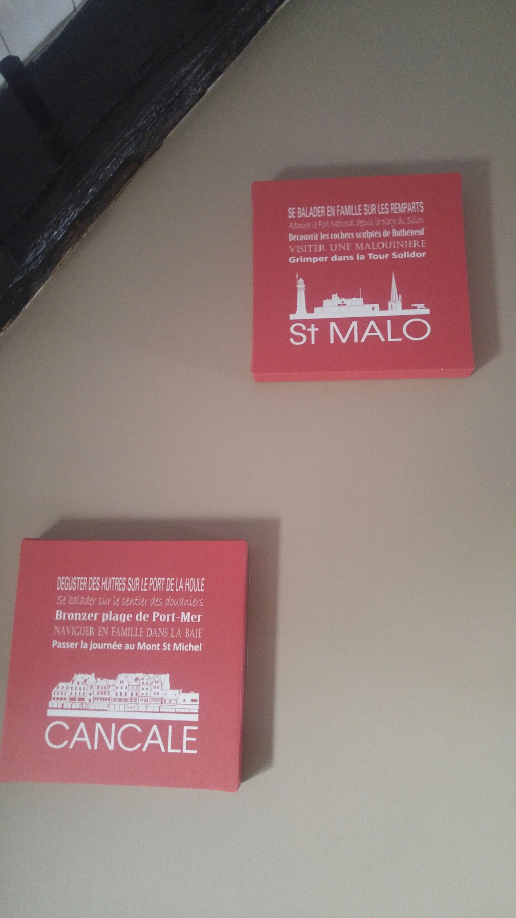 Deux brochures rouges avec du texte blanc et des illustrations de bâtiments.