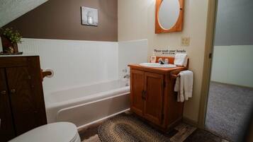 A bathroom with a bathtub, a sink, and a toilet.
