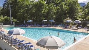 A swimming pool with lounge chairs and umbrellas, surrounded by trees. - Résidence Odalys Acqua Bella (Poggio-Mezzana)