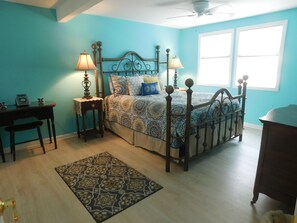 A bedroom with a bed, two bedside tables, a desk, a chair, a rug, and a window. - Beautiful Ocean Terrace Beach House with High-Speed Internet at North End (Seaside Heights)