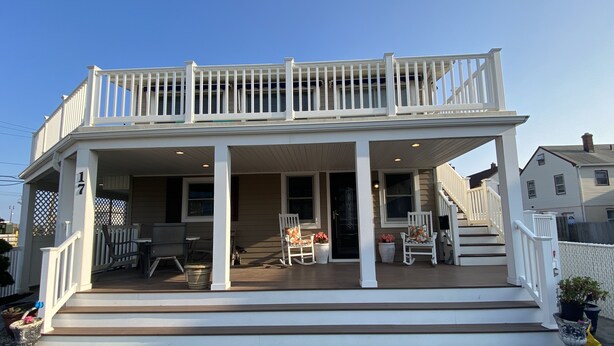 A two-story house with a covered porch, a staircase, and a front door.