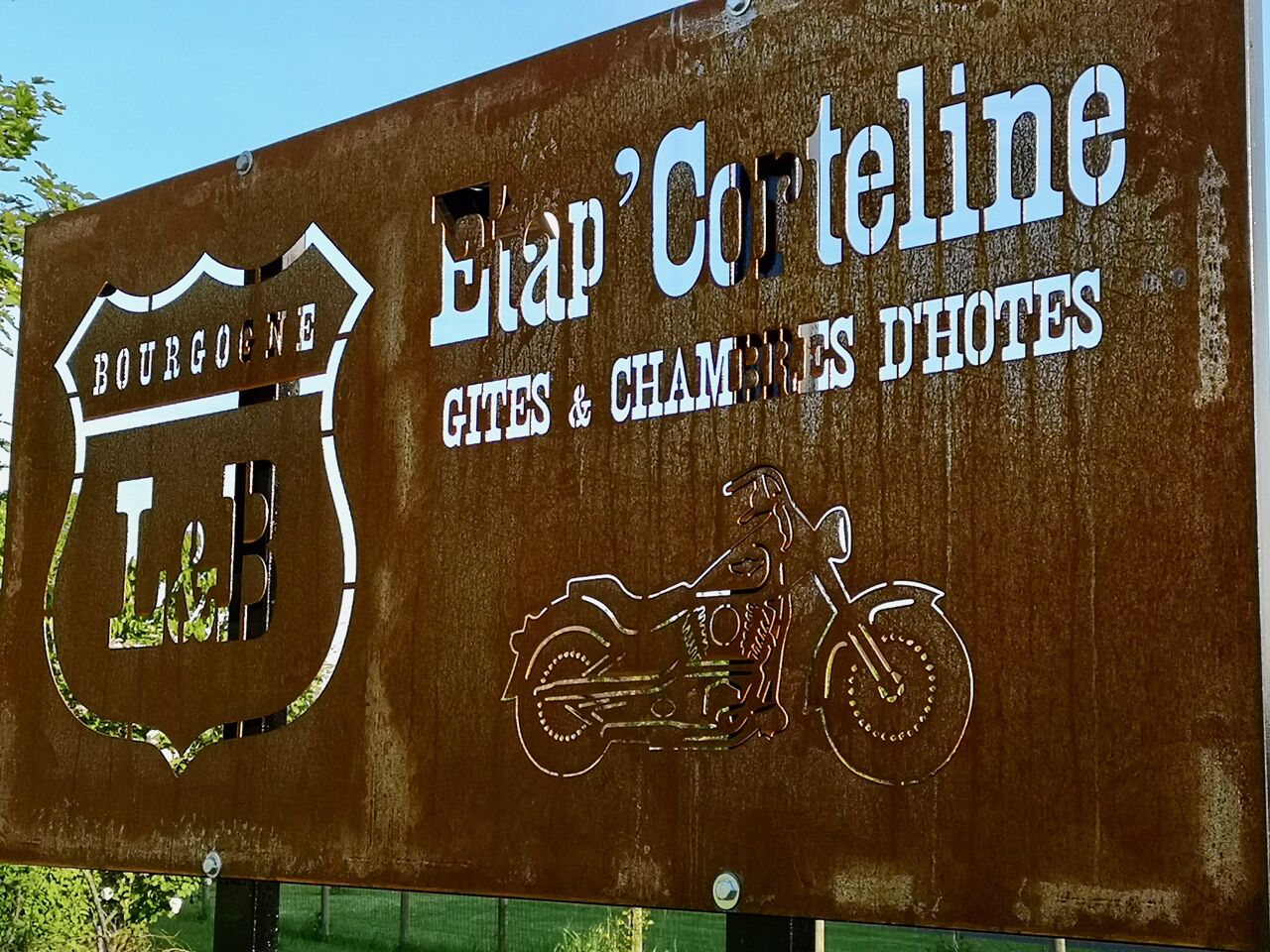Une enseigne pour l’hôtel Etap Corteline, situé en Bourgogne, avec un logo et une illustration de moto.