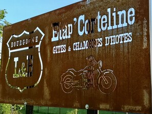A sign for Etap Corteline, a hotel in Bourgogne, featuring a logo and a motorcycle illustration. - L'etap'corteline (Saint-Remy)