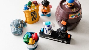 Una colección de juguetes que incluye un set de Star Wars, un barril de juguete y una bolsa de juguete con personajes.