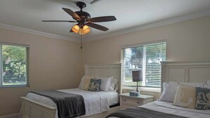 A bedroom with two beds, a ceiling fan, and a nightstand with a lamp. - 3/2 Heated Private Pool, 5 Min to Beach (Lantana)