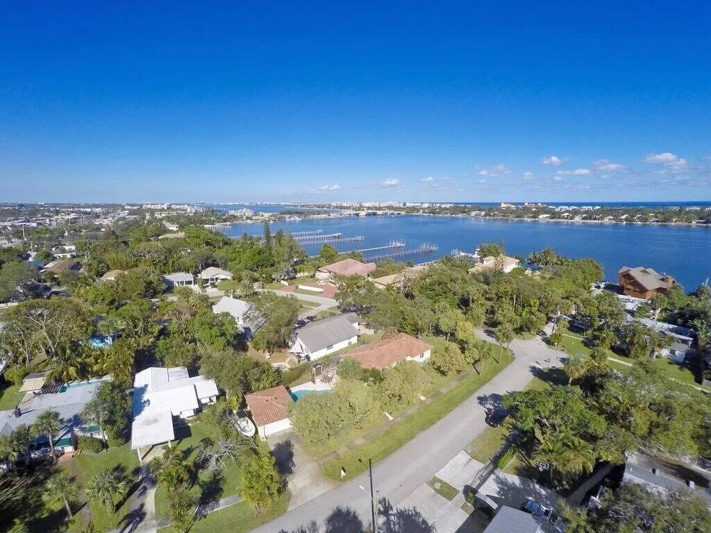 Vue aérienne d’un quartier résidentiel avec des maisons, une marina et une vaste étendue d’eau.