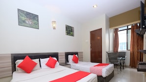 A hotel room with two beds, each with red pillows and a red and white patterned bedspread. There are two wall-mounted light fixtures and two framed pictures on the wall. - OYO 1153 Heaven Hill Hotel 1 (Tanah Rata)