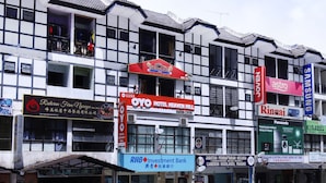 A multi-story building with various commercial establishments including a hotel, bank, and restaurants. - OYO 1153 Heaven Hill Hotel 1 (Tanah Rata)