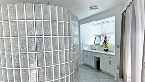 A modern bathroom with a glass partition, a sink, and a mirror. - Seaside Sanctuary 5 bed, 5 bath pool home (Tavernier)