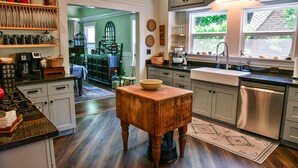 A kitchen with wooden cabinets, a stainless steel dishwasher, and a wooden table. - Charm and Comfort in Quiet Lodi Neighborhood (Lodi)