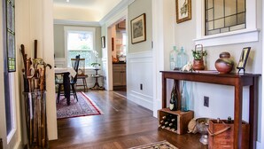 A hallway with a wooden floor, a red rug, a glass vase, and a wine rack. - Charm and Comfort in Quiet Lodi Neighborhood (Lodi)