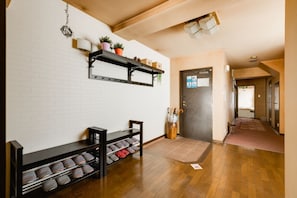 Enter a serene hallway with a wooden floor, lined with a shelf and a door.