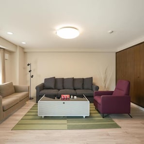 Un salon moderne comprenant un canapé, un fauteuil, une table basse et un lampadaire.