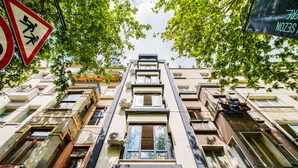 A multi-story building with a central staircase, air conditioning units, and a pedestrian crossing sign. - Mitani Suites (Istanbul)
