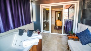A bathroom with a bathtub, towels, and a glass of red wine. - Mitani Suites (Istanbul)