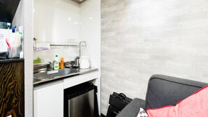 A modern kitchen with a stainless steel sink, a coffee maker, and a dishwasher. - Tsuruhashi Guest House (Osaka)