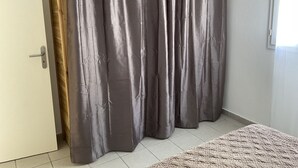 A room with a grey curtain, a wooden door, and a tiled floor. - Villa Bougainvilliers with private pool in Le Diamant (le diamant)