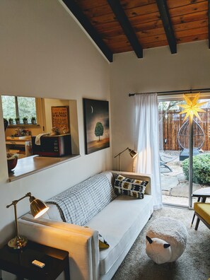 A cozy living room with a sofa, a lamp, and a large window with a view of the outdoors. - ⭐️Positive Energy! Sedona's best vortex location!  (Sedona)