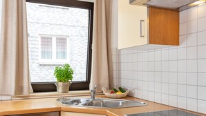 A kitchen with a window, a sink, a stove, and a dishwasher. - Fantastic holiday apartment with beautiful views to the sea, it is dog friendly (Wittdün)