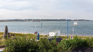 A waterfront view with boats, a small dock, and a grassy area with a sign. - Fantastic holiday apartment with beautiful views to the sea, it is dog friendly (Wittdün)