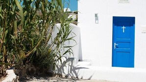 Un edificio blanco con una puerta azul y un campanario.