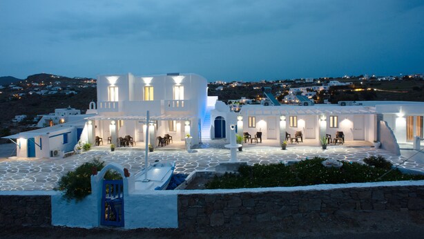 Un edificio blanco con varias habitaciones y un patio.