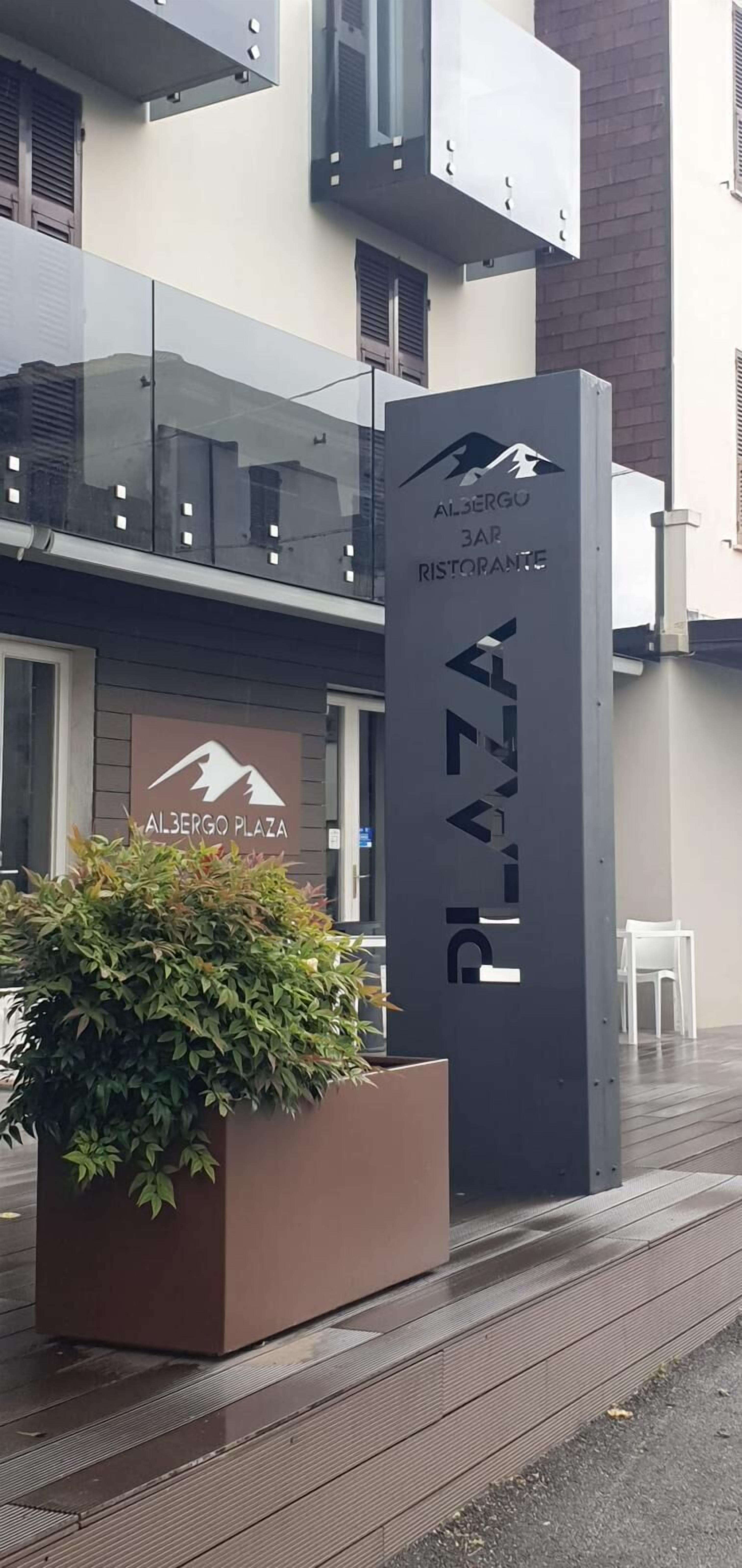 A modern building with a sign for 'Albergü 3 Bar Restaurante' and 'Al.3ergo Plaza'.