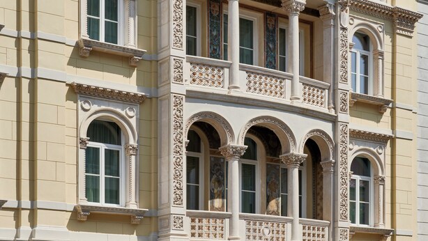 A multi-story building with ornate architectural details, including columns, arches, and decorative moldings.