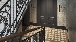 A multi-level staircase with ornate metal railings and a checkered floor pattern.