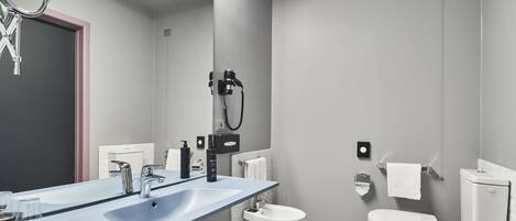 Ein modernes Badezimmer mit einem blauen Waschtisch, weißen Sanitärobjekten und einem Schachbrettfußboden.