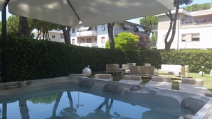 Area con idromassaggio, posti a sedere all'aperto e vista su edifici residenziali.