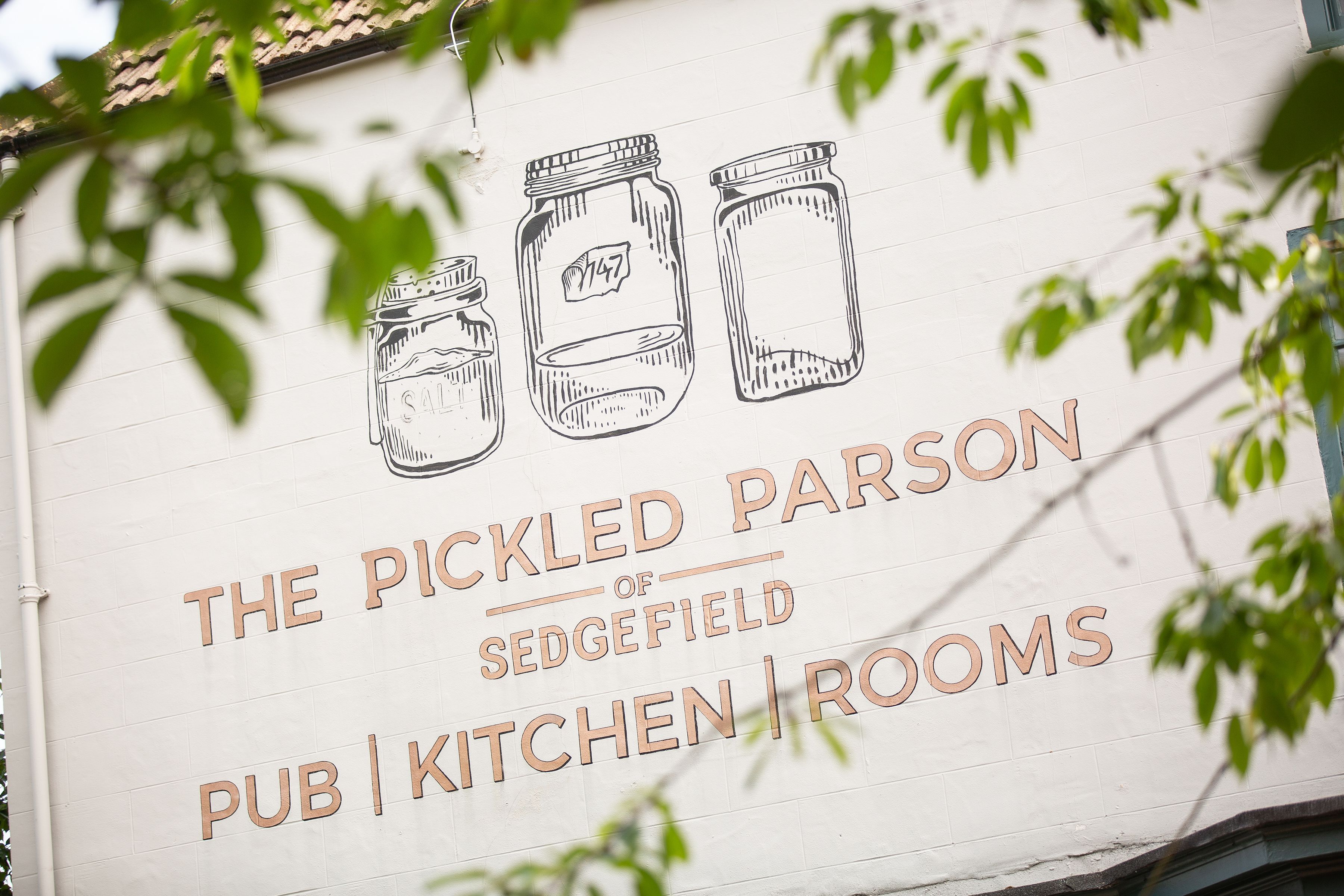 A sign for The Pickled Parson of Sedgefield Pub | Kitchen Rooms with illustrations of jars.